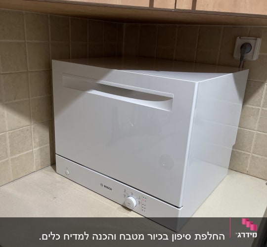 מדיח כלים קטן על משטח מטבח ליד שקע חשמל